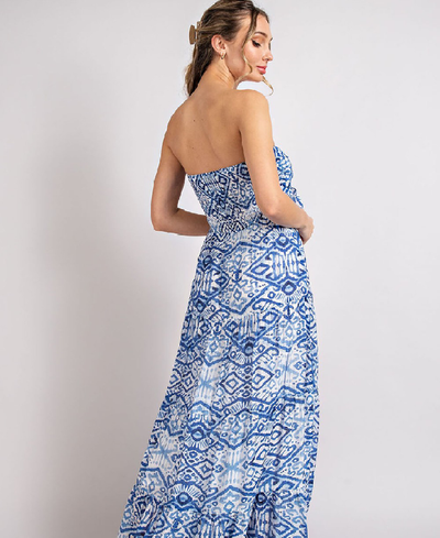 Back view of the Off the shoulder maxi dress featuring a smocked bodice  with a tie front and a tiered design. Model is 5'8" and wearing a small.