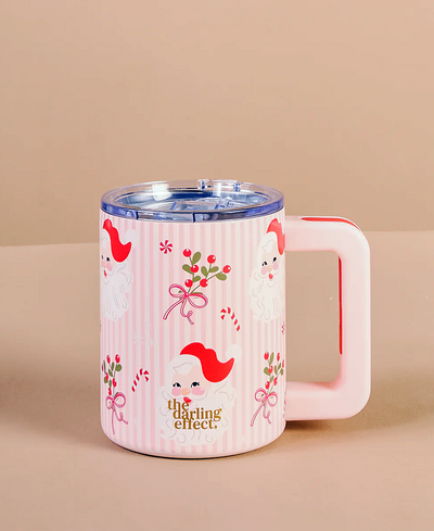 Pink mug with cartoon santa design on a beige background