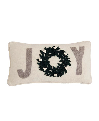 Decorative pillow with 'JOY' and a wreath design on a white background