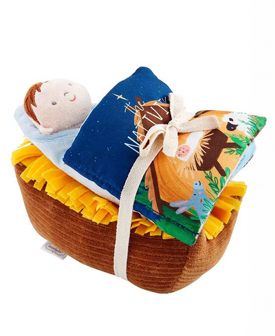 Picture of stuffed baby and nativity book tied with a bow