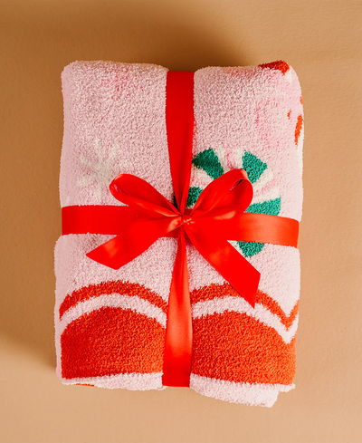 Folded blanket with a red ribbon on a beige background