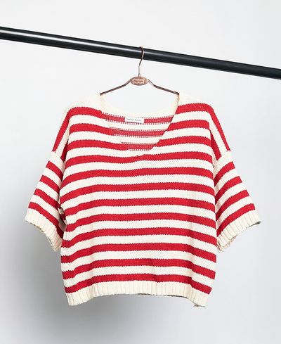 Red and white striped sweater on a hanger against a white background