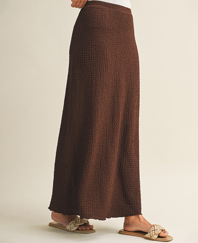 Brown textured skirt worn by a person on a beige background