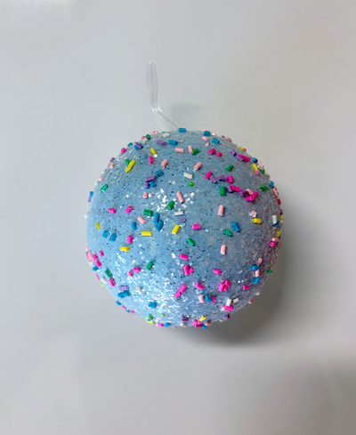 Blue ball ornament with colorful sprinkles on a white background