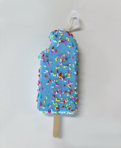 Blue ice cream popsicle-shaped toy with colorful sprinkles on a light gray background