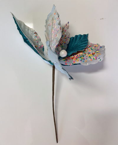 Decorative tree pick with teal and silver leaves on a white background