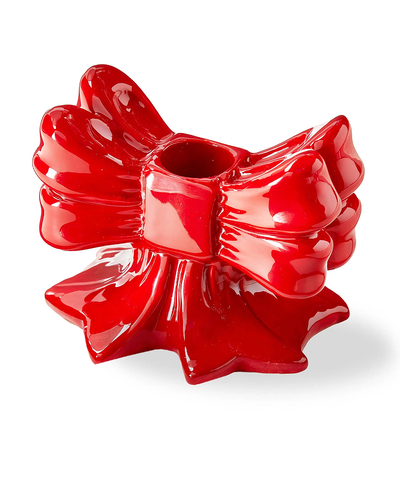 Red decorative candle holder shaped like a bow on a white background