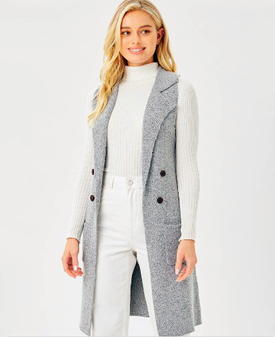 Woman wearing a gray vest over a white outfit on a white background