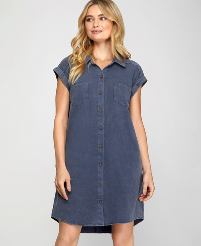 Woman wearing a denim dress against a plain background