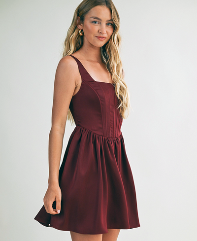 Woman wearing a burgundy dress against a plain background