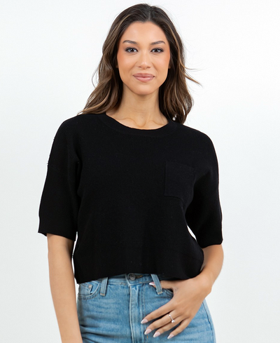 Woman wearing a black top and blue jeans on a white background