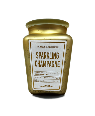 Gold candle jar labeled 'Sparkling Champagne' on a white background