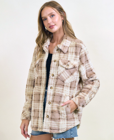 Woman wearing a plaid jacket with a neutral background