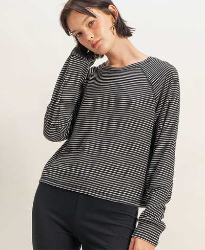 Woman wearing a black and white striped long-sleeve top on a plain background