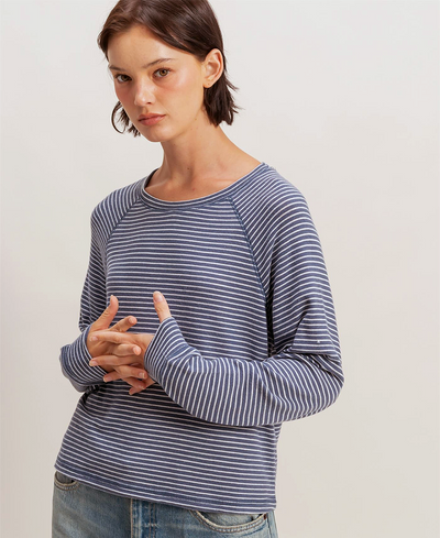 Woman wearing a blue and white striped sweater against a plain background