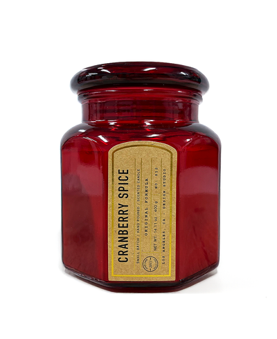 Red candle jar with a label on a white background