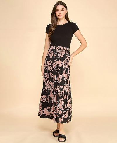 Woman wearing a black top and floral skirt on a beige background