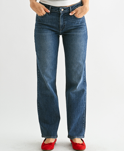 Person wearing blue jeans with red shoes on a white background