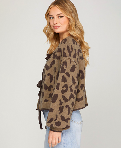 Woman wearing a leopard print cardigan on a plain background