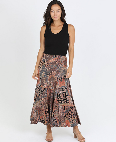 Woman wearing a black top and patterned skirt on a white background