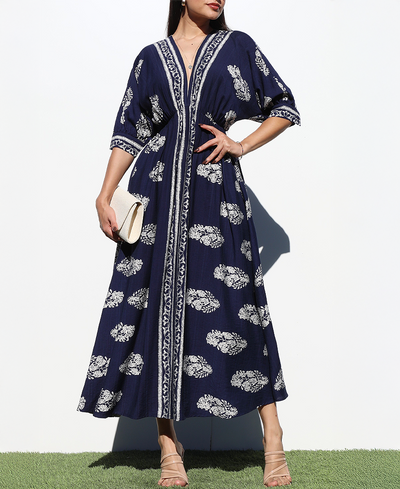 Woman wearing a navy blue dress with white floral patterns on a white background