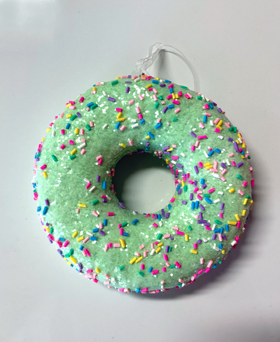 Green donut with colorful sprinkles on a white background