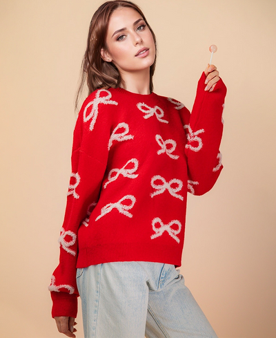 Woman wearing a red sweater with white patterns against a beige background