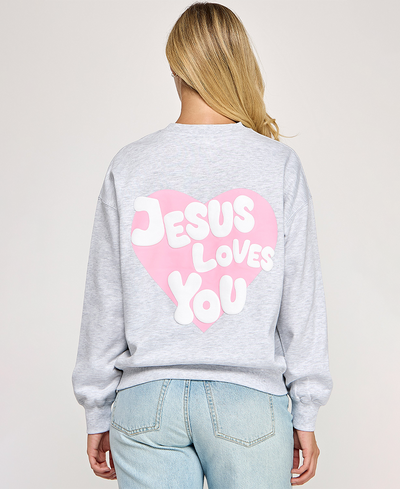 Person wearing a gray sweatshirt with 'Jesus Loves You' text on the back against a plain background