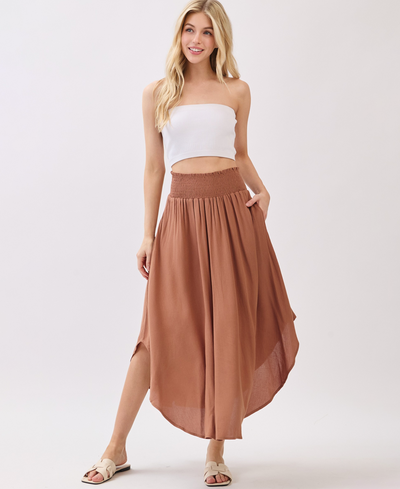 Woman wearing a white top and brown skirt on a white background