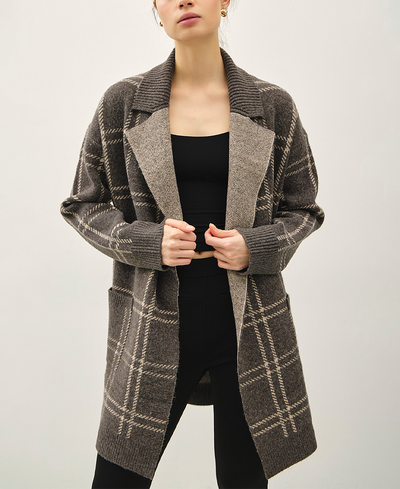 Person wearing a brown checkered coat on a plain background