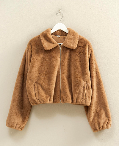 Brown fuzzy jacket on a hanger against a beige background