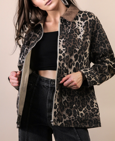 Person wearing a leopard print jacket over a black top and jeans on a beige background