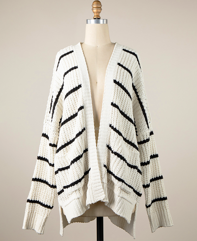White cardigan with black stripes on a mannequin against a beige background