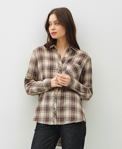 Woman wearing a plaid shirt against a plain background