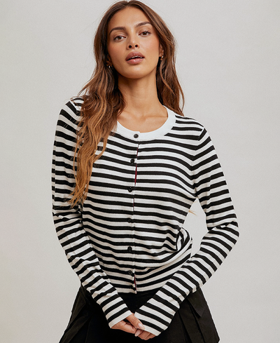 Woman wearing a black and white striped long-sleeve cardigan against a plain background