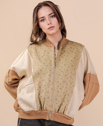 Woman wearing a beige and brown jacket with floral pattern on a beige background