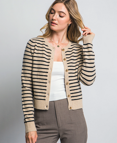 Woman wearing a striped cardigan over a white top and gray pants on a light gray background