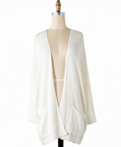 White cardigan on a mannequin against a white background