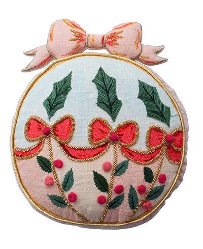 Decorative pillow with embroidered design of bows, leaves, and berries on a white background