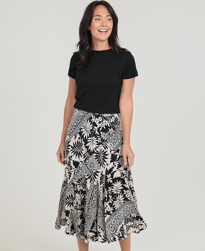 Woman wearing a black t-shirt and a black and white floral skirt on a gray background