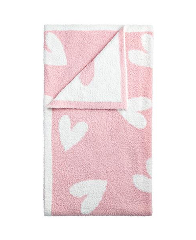 Pink blanket with white heart patterns on a white background