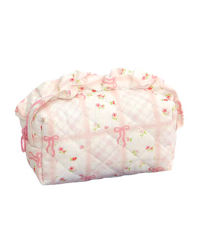 Pink quilted bag with bow designs on a white background