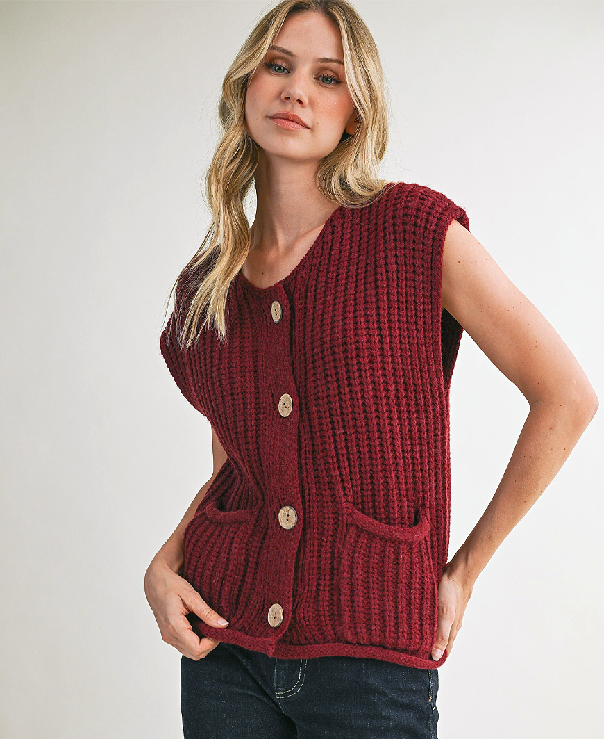 Woman wearing a red knitted vest against a white background