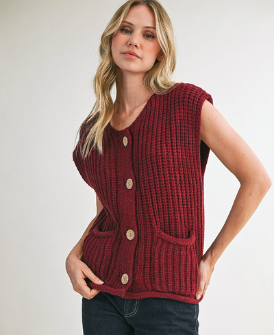 Woman wearing a red knitted vest against a white background