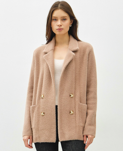 Woman wearing a brown teddy coat with gold buttons on a white background