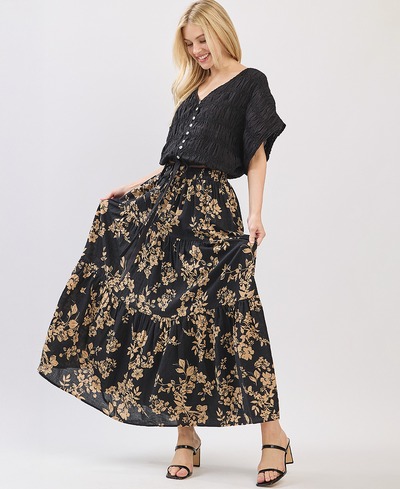 Woman wearing a black top and floral skirt on a white background