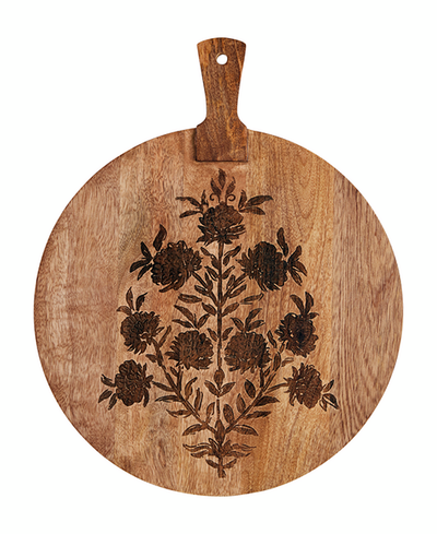 Round wooden cutting board with floral patterns and a handle on a white background