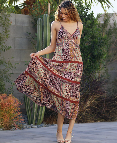 Woman in a patterned dress standing outdoors with cacti in the background