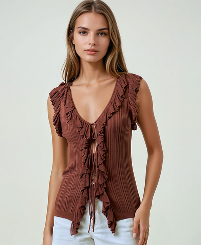 Woman wearing a brown ruffled top against a plain background