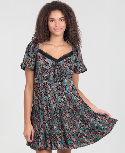 Woman wearing a floral patterned dress on a plain background